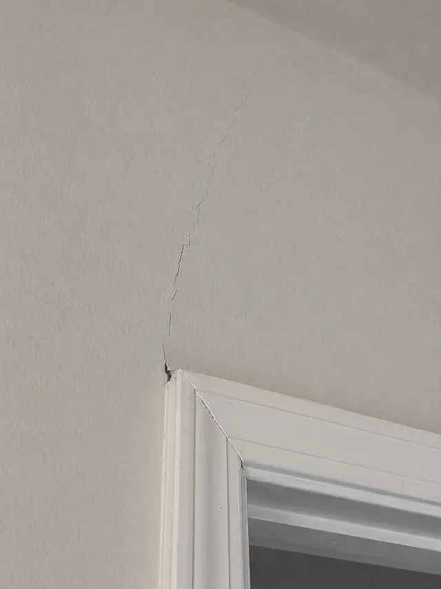 Drywall crack extending above a doorway